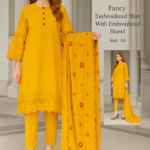 A printed catalog page displaying a woman wearing a bright yellow embroidered suit with a matching embroidered shawl, featuring detailed floral embroidery and velvet border, set against an elegant indoor backdrop.