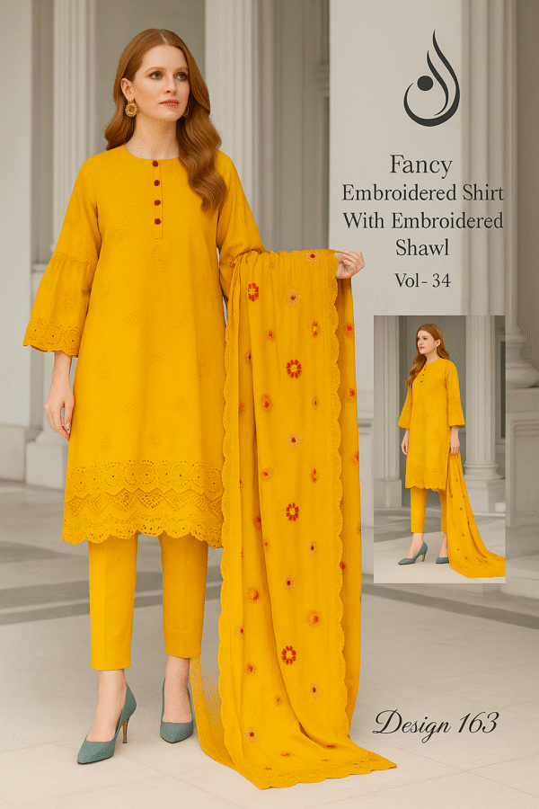 A printed catalog page displaying a woman wearing a bright yellow embroidered suit with a matching embroidered shawl, featuring detailed floral embroidery and velvet border, set against an elegant indoor backdrop.
